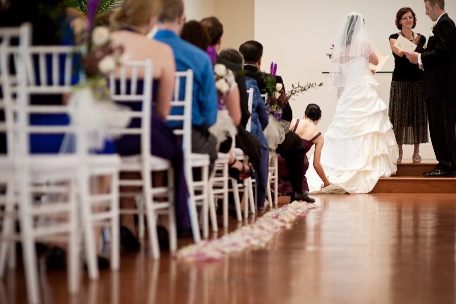 ritz-charles-wedding-photography-DE-9 bridesmaid adjusting wedding gown during ceremony