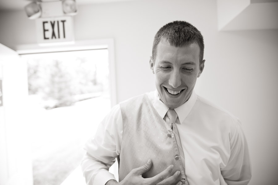 ritz-charles-wedding-photography-DE-4 groom putting on vest before indianapolis wedding