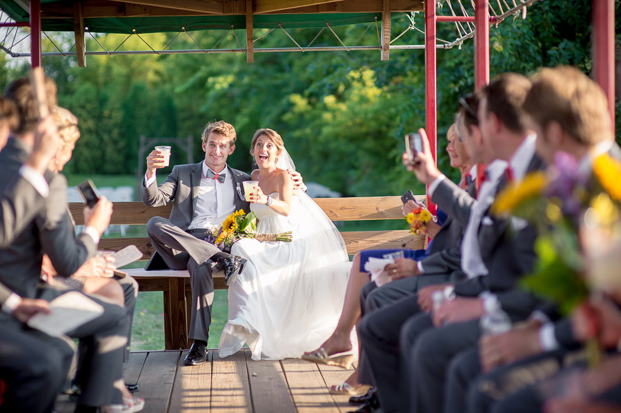 bride, groom and bridal party on tractor after wedding ceremony at apple orchard