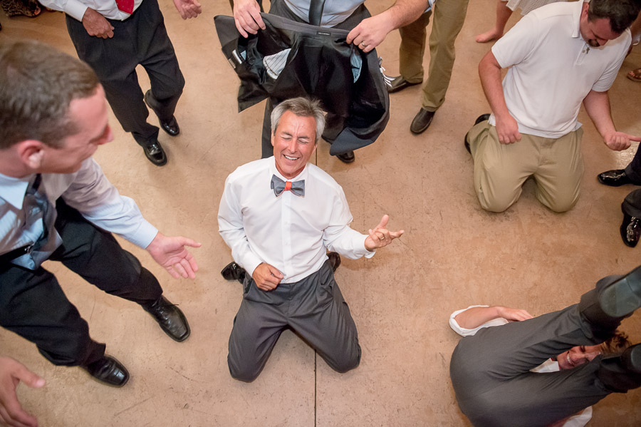 Hilarious photo of father of the bride playing air guitar at wedding reception at apple orchard