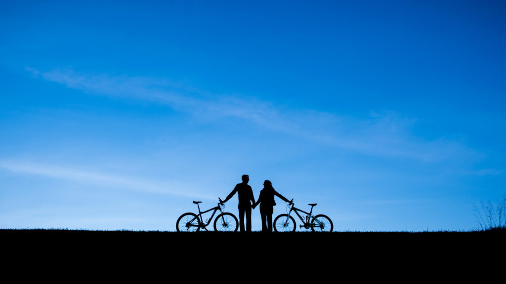 Minimalistic and silhouetted engagement photo with bikes